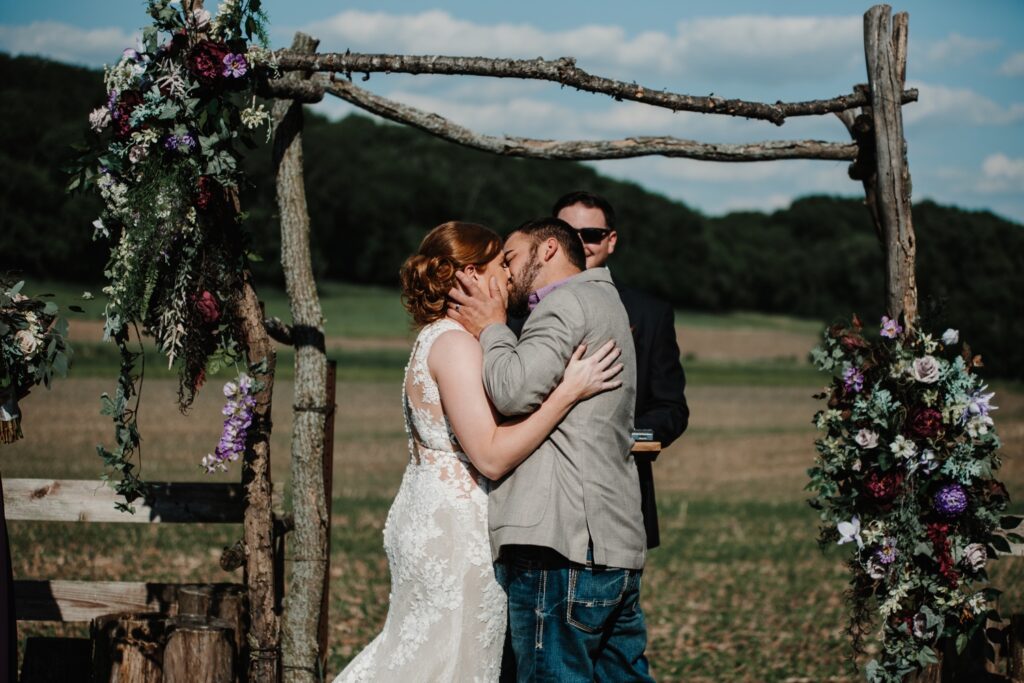 Bride and groom first kiss at rustic Reichert's Barn Wedding