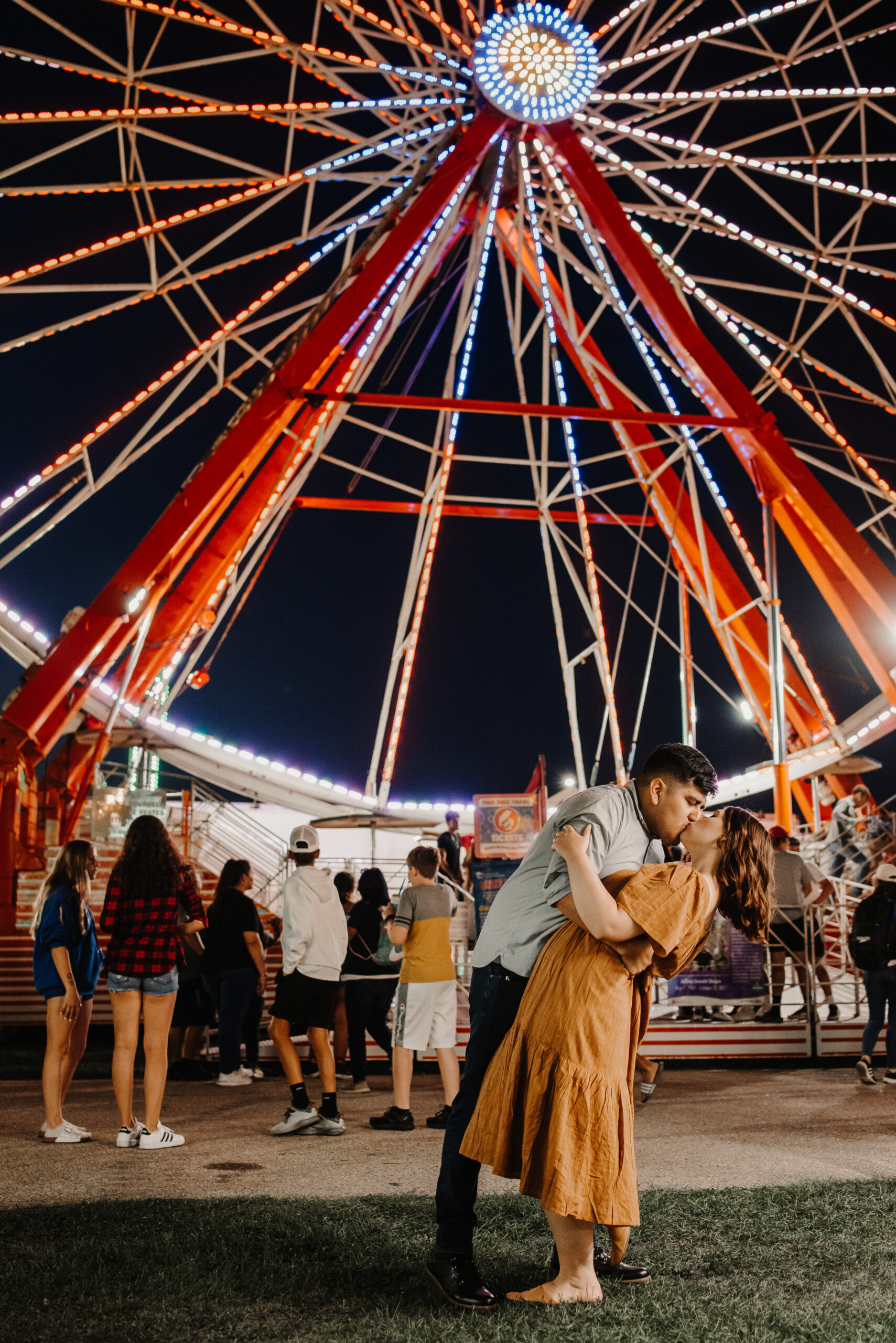 couple kisses in front of ferris wheel in wisconsin