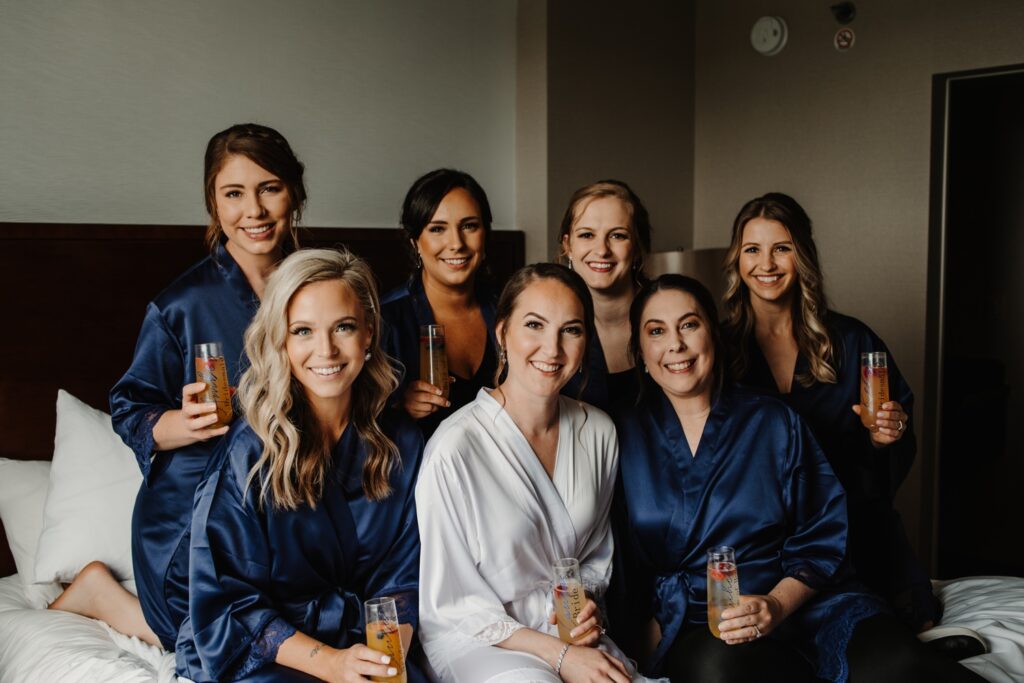 Bride and bridesmaids share mimosas before golf course wedding
