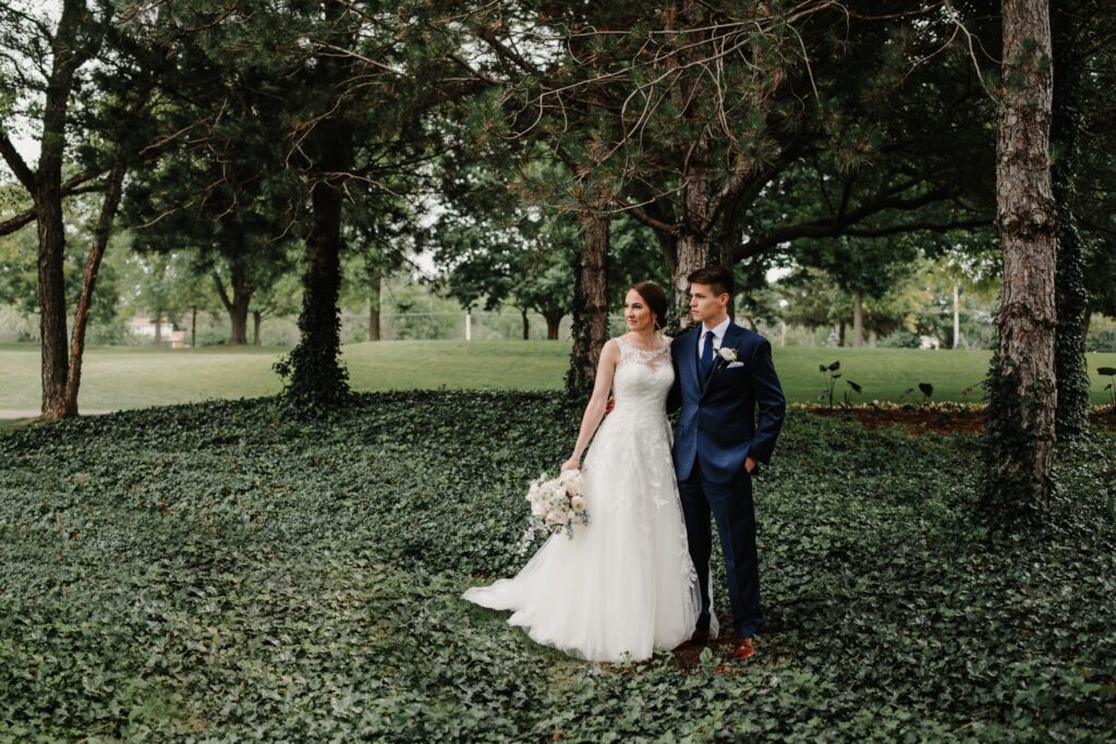Bride and groom standing in greenery at golf course wedding