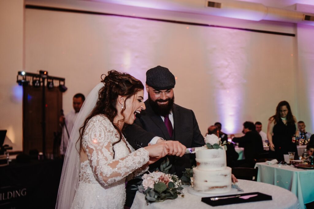 Bride and groom cut cake at Legacy Building wedding reception
