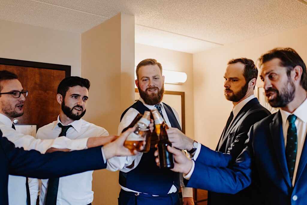 Second photographer documents groomsmen getting ready on his wedding day.
