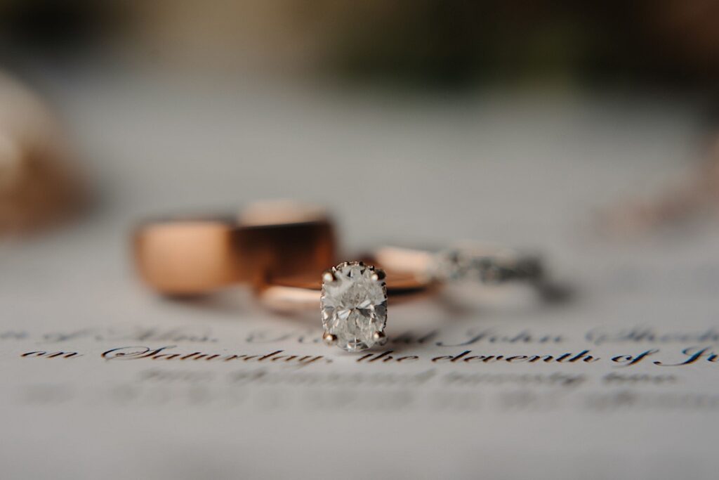 A close up image of an oval cut diamond on a rose gold wedding ring.