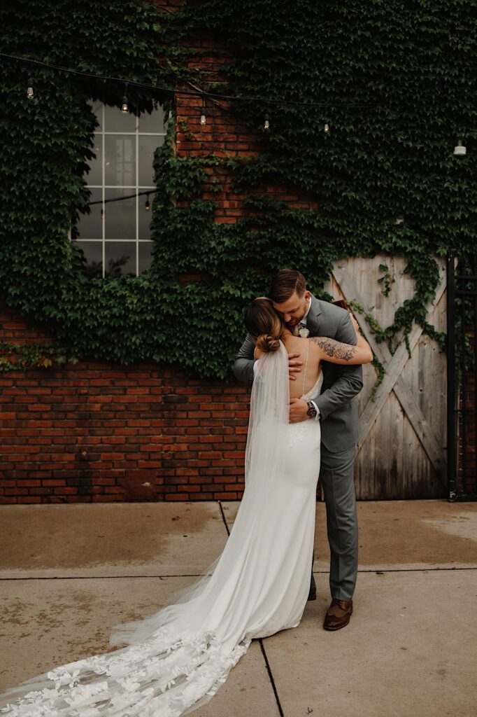 A groom hugs the bride after seeing her for the first time on their wedding day outside their wedding venue.
