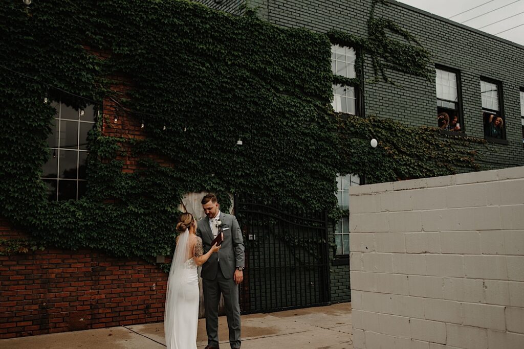 A bride and groom stand outside the Ivy House and share their wedding vows privately after their first look.