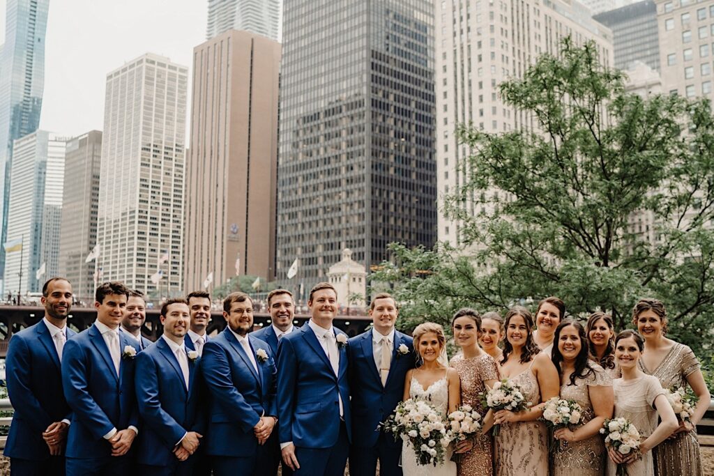 The newlyweds and their wedding party take wedding party photos on the Chicago Riverwalk.