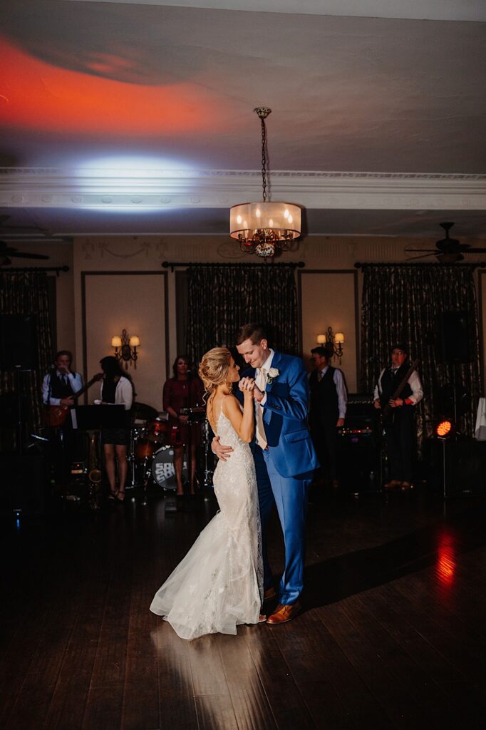 A bride and groom share their first dance together on their wedding day with a live band behind them