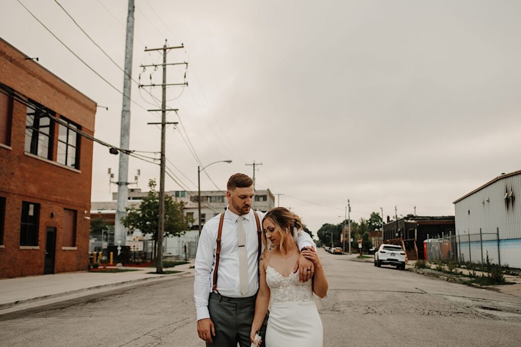 A bride and groom walk down the street together outside of their wedding venue Ivy House after sneaking away during the reception for some portraits.