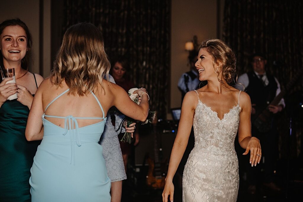 A bride laughs at her friends beside her during her wedding reception at Salvatore's in Chicago