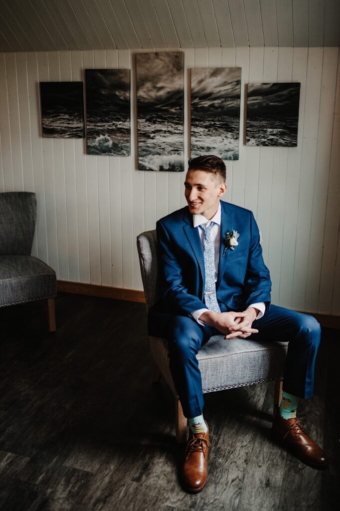 The groom sits in his wedding venue getting ready space at his Wisconsin wedding venue, the 1841 Farms and Vineyard.