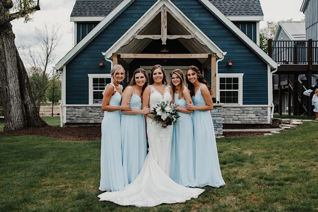 A bride and her bridesmaids stand in front of the getting ready space at 1841 Farms and Vineyard