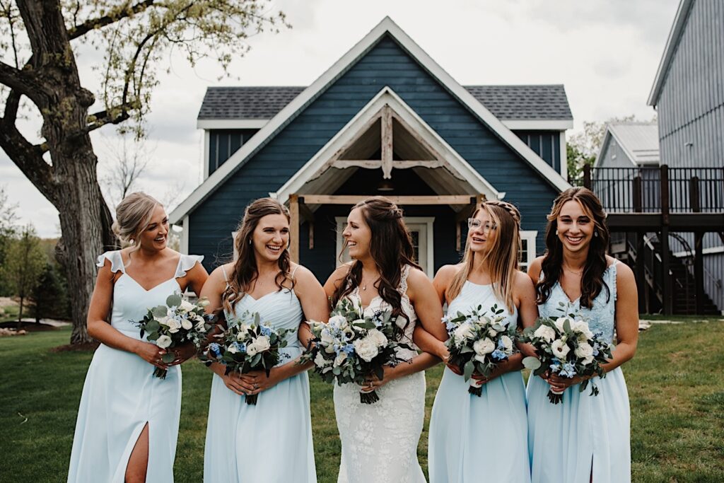 the bride and her bridesmaids walk towards the camera holding their bouquets