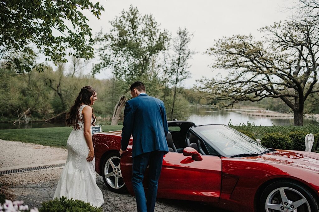 The bride and groom climb into a sports car after their wedding at 1841 Farms and Vineyard in Wisconsin.