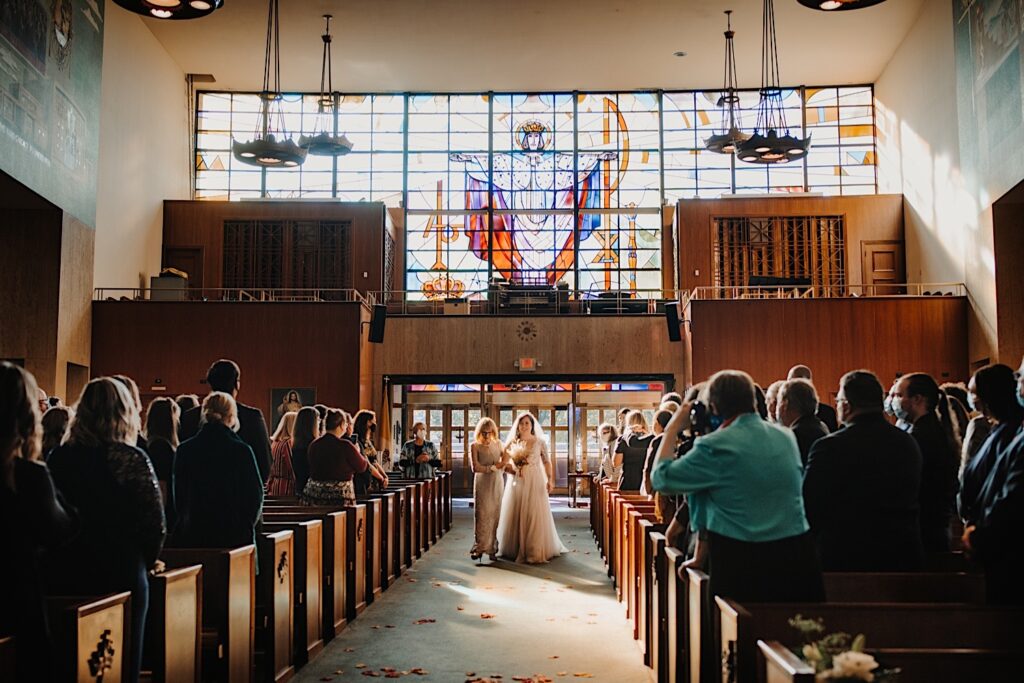 A bride is walked down the aisle by her mother during her fall wedding ceremony in Chicago