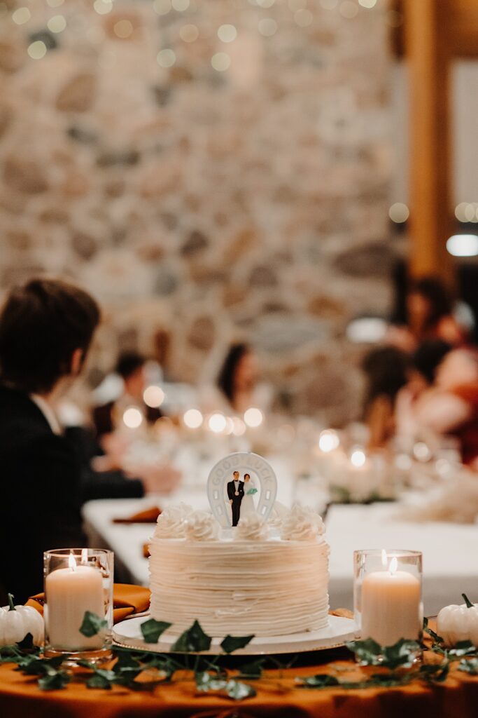 Detail photo of a wedding cake surrounded by candles and other wedding decorations