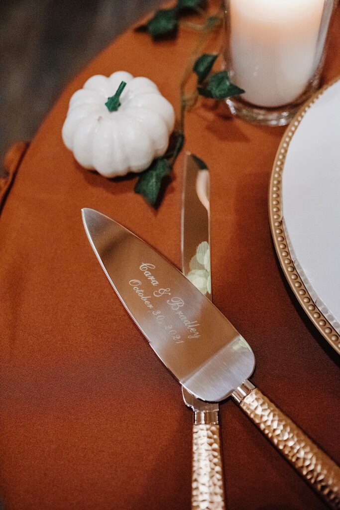 Detail photo of a cake cutting knife which reads "Cara & Bradley October 30, 2021"