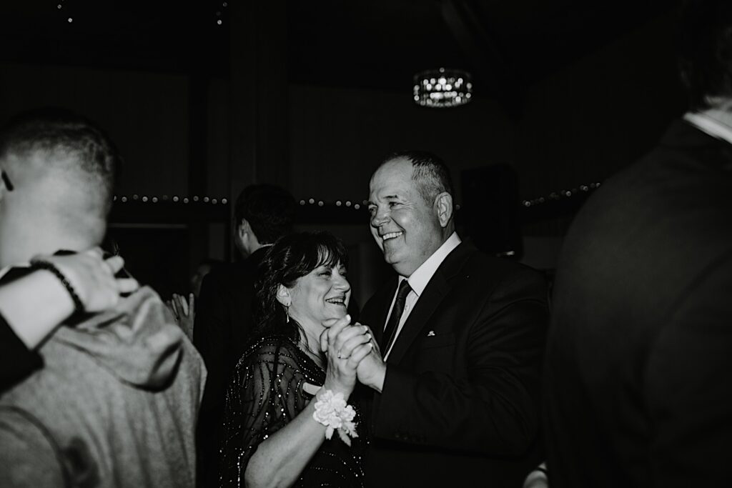 Black and white photo of guests of a wedding dancing during the reception at the Oakbrook Bath and Tennis club