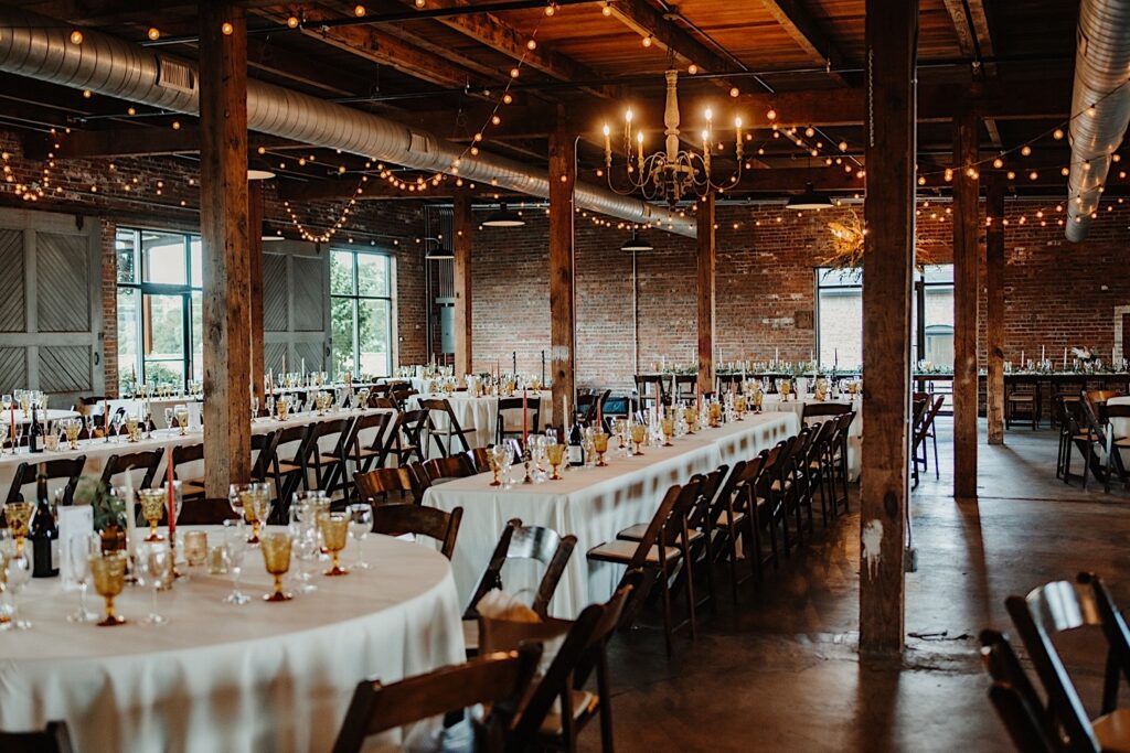 Tables set up and decorated for a wedding inside The Cannery's indoor reception space