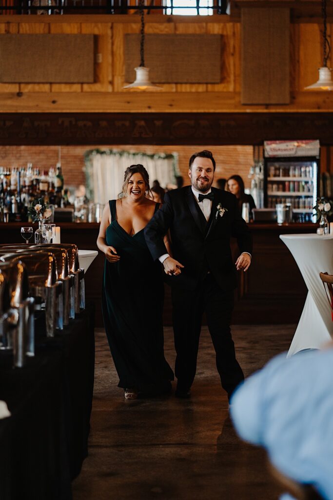A bridesmaid and groomsman walk together as they enter the wedding reception area