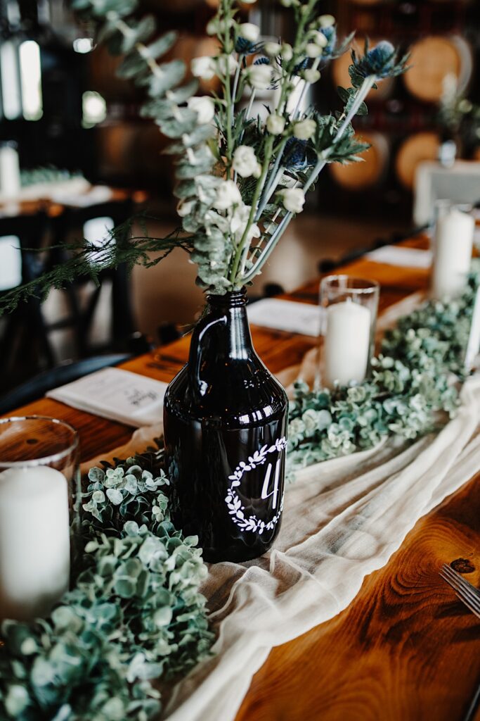 A beer growler with the number 4 on it set up on a table for a wedding reception