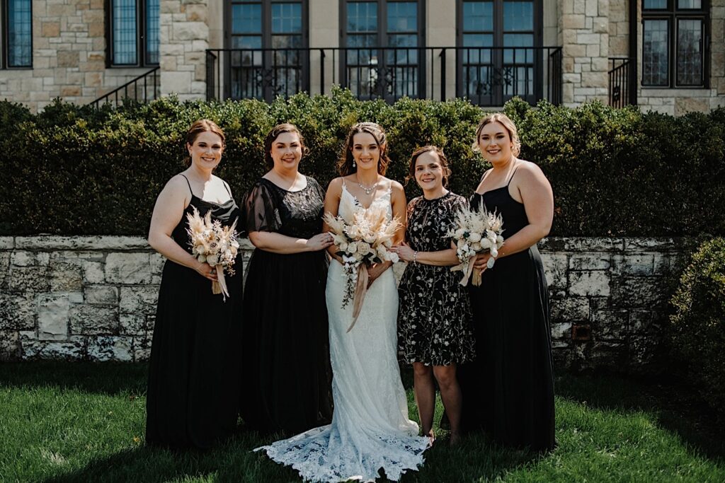 A bride stands in the middle of a group of 4 women including her mother, soon to be mother in law, and two bridesmaids