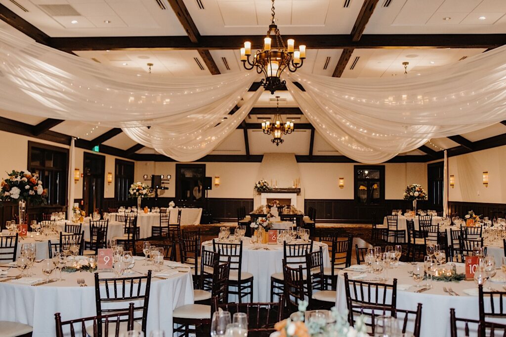 The indoor reception space of Mistwood Golf Club decorated for a fall wedding reception