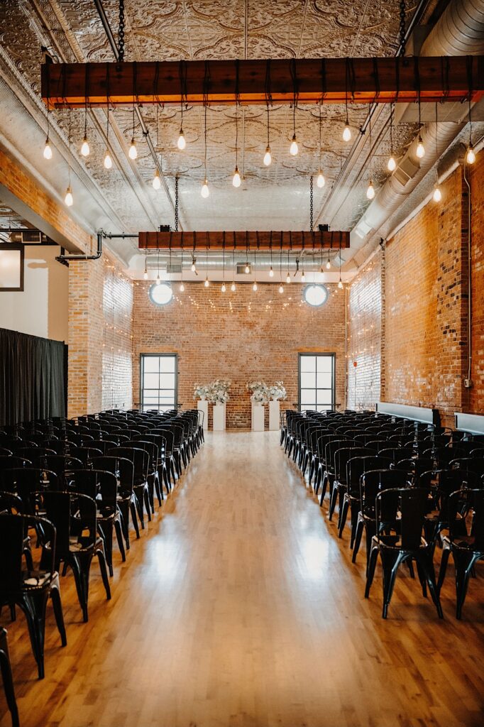 An indoor brick ceremony space at Venue CU set up and decorated for a wedding ceremony