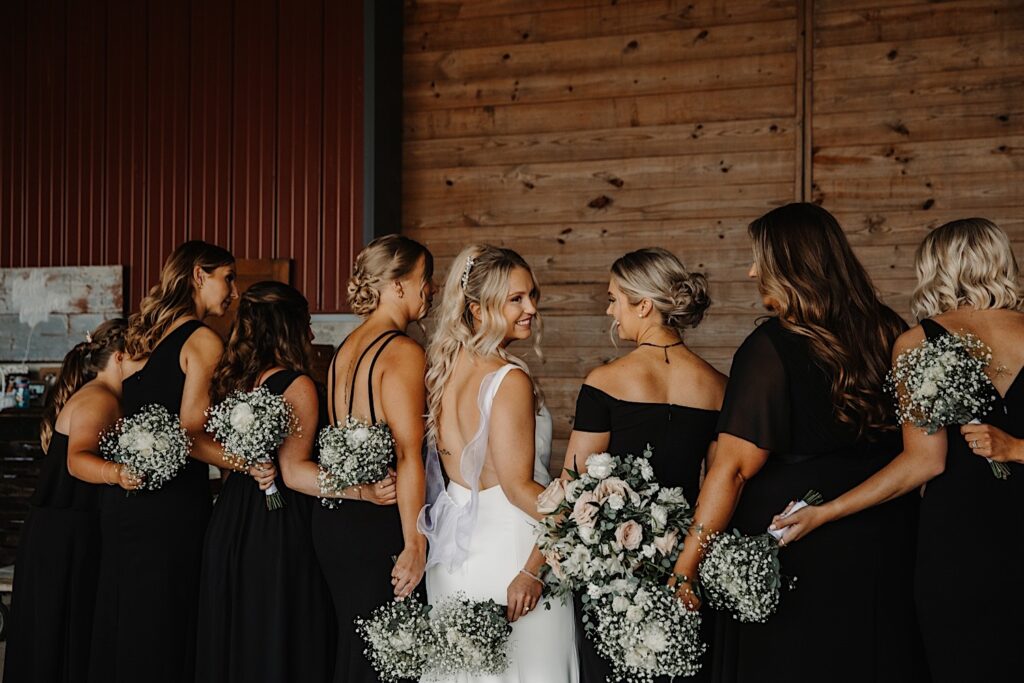 A bride stands beside her 7 bridesmaids for a photo at the venue of her wedding day