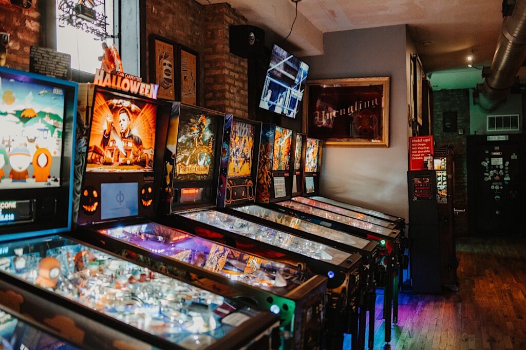 Photo of pinball machines lining the wall of a brick bar in Chicago