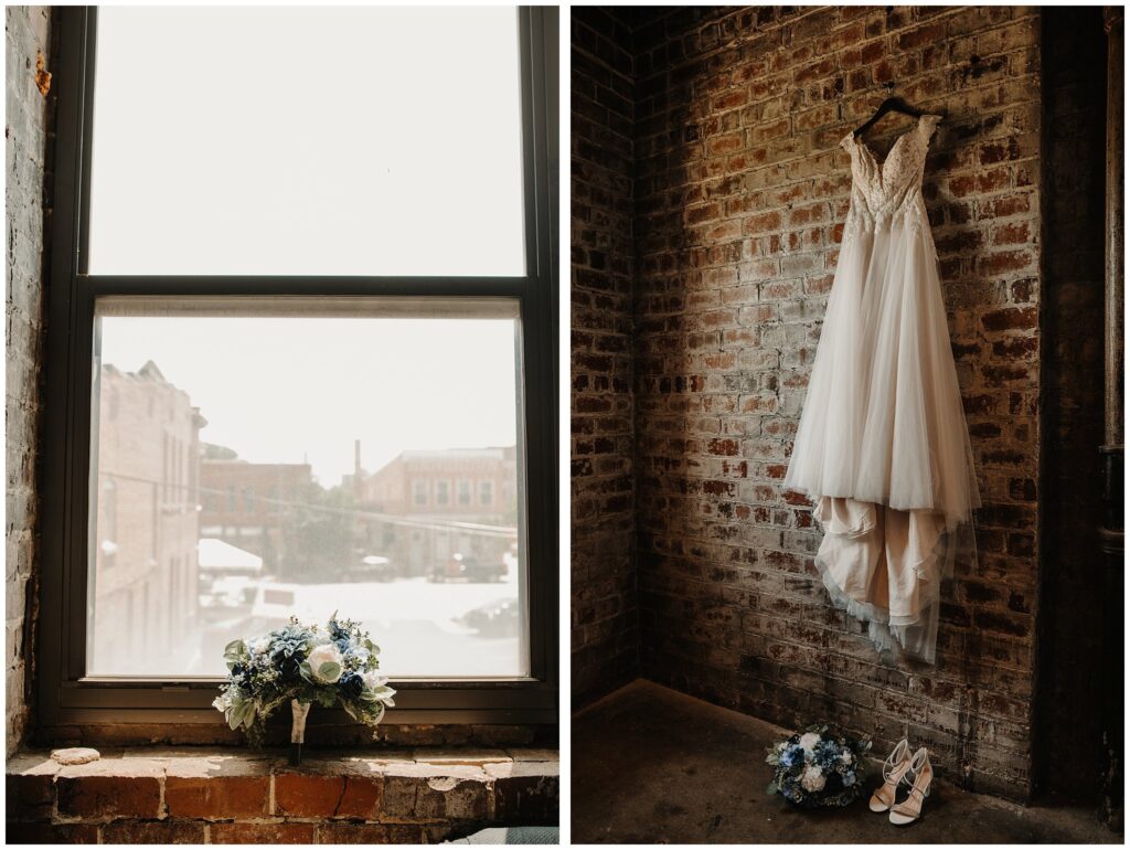 wedding florals against large window with brick background at the castle theater in bloomington illinois, romantic off the shoulder wedding dress hanging against a moody brick wall